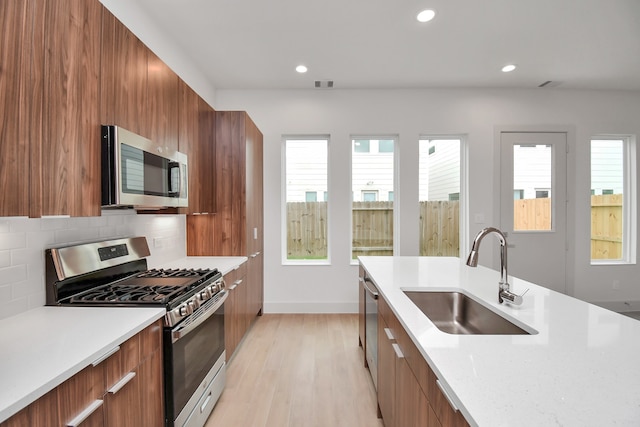 kitchen featuring backsplash, plenty of natural light, stainless steel appliances, and sink