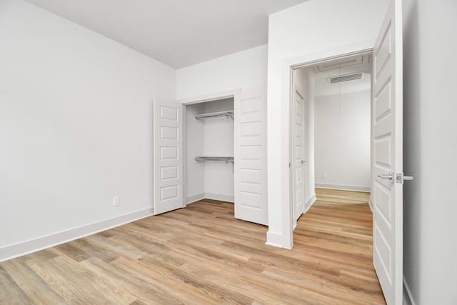 unfurnished bedroom with light wood-type flooring and a closet