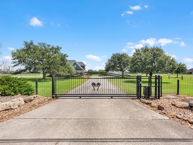 view of gate with a yard