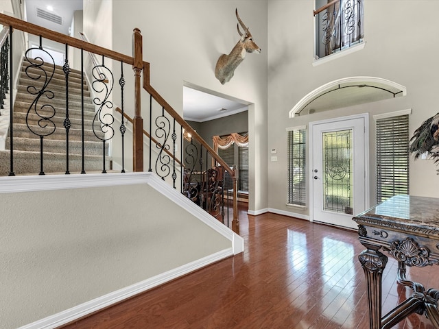 entryway with hardwood / wood-style flooring and a towering ceiling