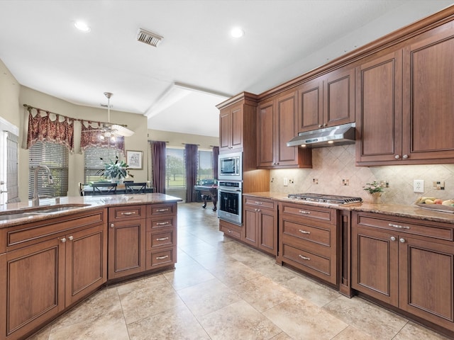 kitchen featuring backsplash, hanging light fixtures, sink, light stone countertops, and appliances with stainless steel finishes