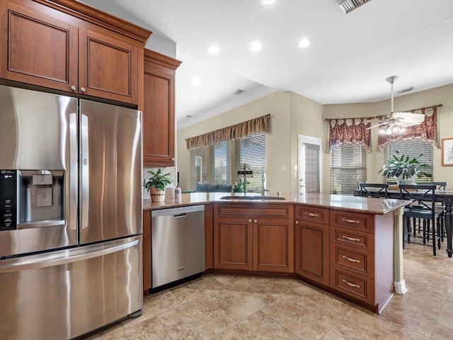 kitchen featuring kitchen peninsula, light stone counters, ornamental molding, stainless steel appliances, and sink