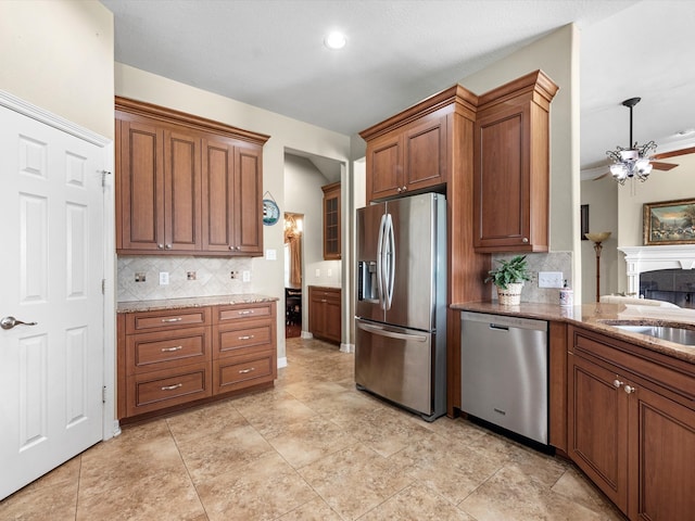 kitchen featuring decorative backsplash, appliances with stainless steel finishes, ceiling fan, and sink