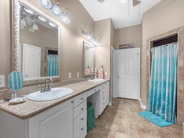 bathroom with ceiling fan, vanity, and vaulted ceiling