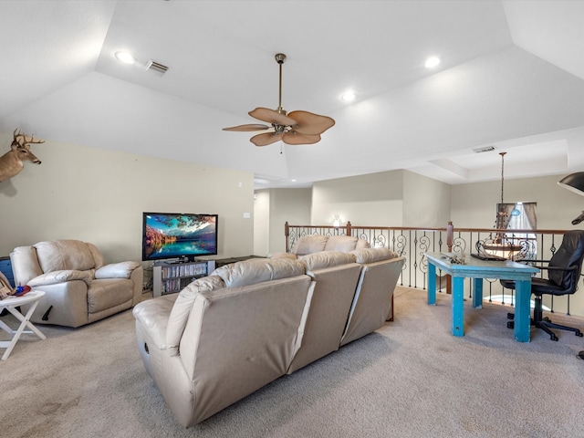 carpeted living room with a tray ceiling and ceiling fan