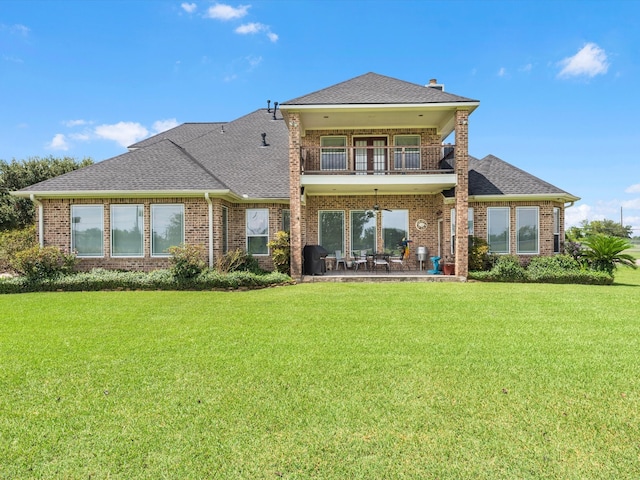 back of house with a yard, a balcony, and a patio area