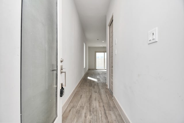 hallway with light hardwood / wood-style floors