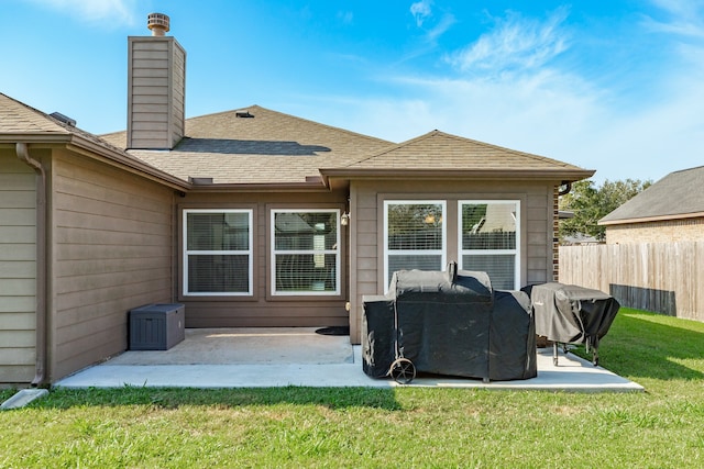 rear view of house with a patio and a lawn