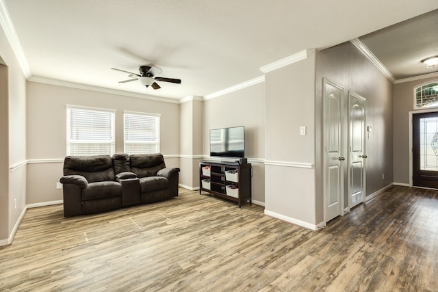 living room featuring hardwood / wood-style floors, crown molding, ceiling fan, and a healthy amount of sunlight