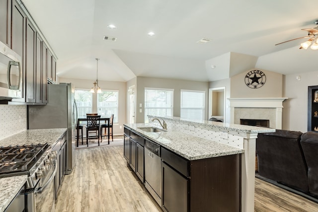 kitchen with light wood-type flooring, dark brown cabinets, stainless steel appliances, vaulted ceiling, and sink