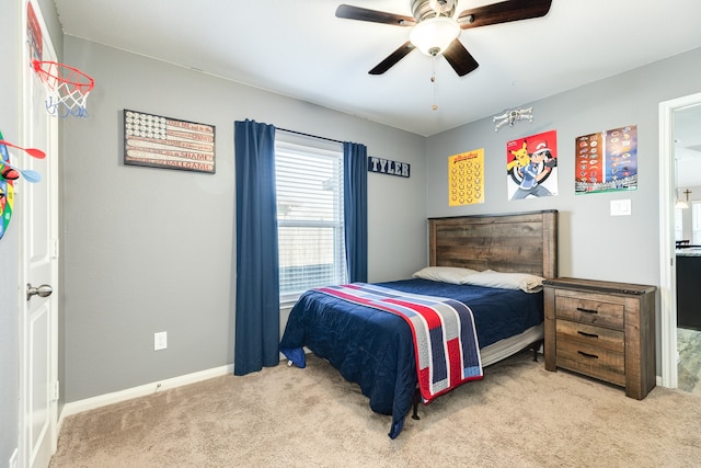 carpeted bedroom featuring ceiling fan with notable chandelier and ensuite bathroom