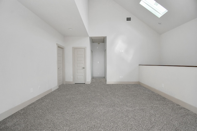 unfurnished room featuring carpet flooring, high vaulted ceiling, and a skylight