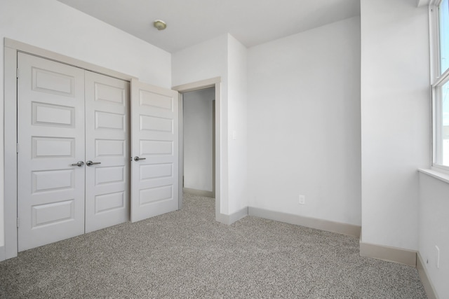 unfurnished bedroom with carpet flooring and a closet