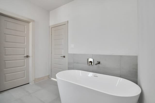 bathroom with tile walls and a tub