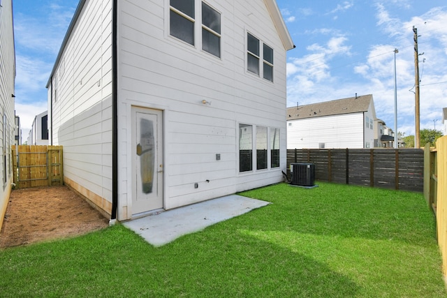 back of house with a yard and central AC