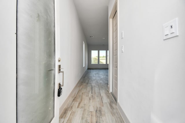 corridor with light hardwood / wood-style floors