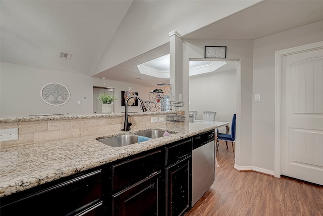 kitchen with dishwasher, sink, vaulted ceiling, hardwood / wood-style flooring, and light stone countertops