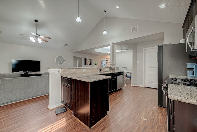 kitchen featuring dark brown cabinetry, ceiling fan, light stone countertops, decorative light fixtures, and light wood-type flooring