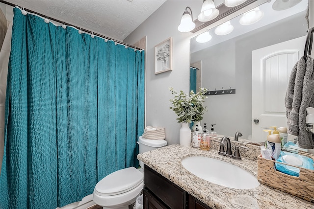 bathroom with vanity, a textured ceiling, and toilet