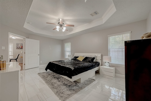 bedroom featuring a textured ceiling, a raised ceiling, ceiling fan, and ornamental molding