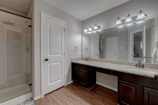 bathroom with hardwood / wood-style flooring, vanity, and an enclosed shower