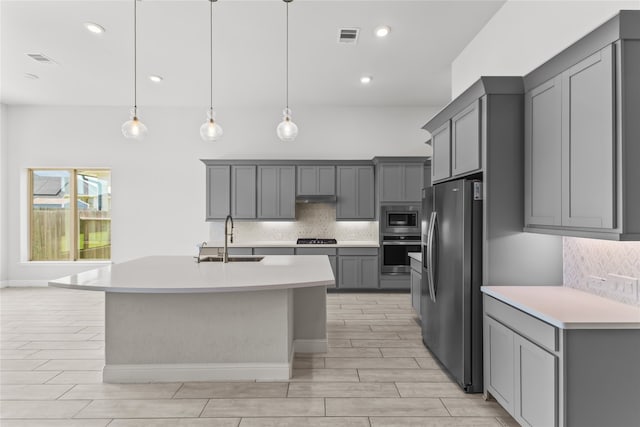 kitchen with stainless steel appliances, gray cabinetry, and sink