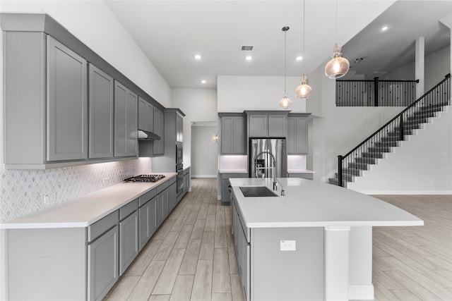 kitchen with a large island, gray cabinets, and light hardwood / wood-style floors