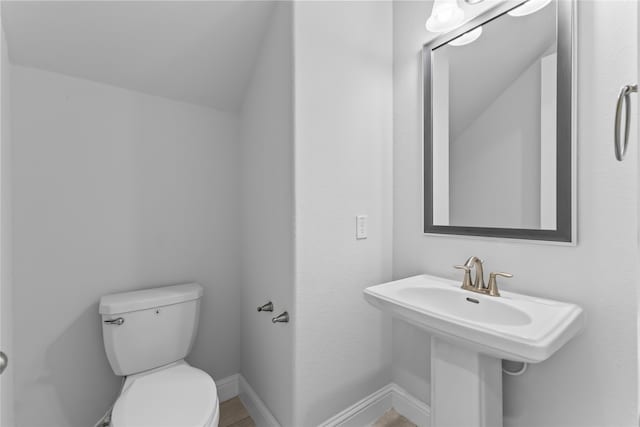 bathroom with toilet and lofted ceiling