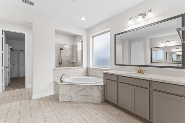 bathroom featuring vanity and independent shower and bath