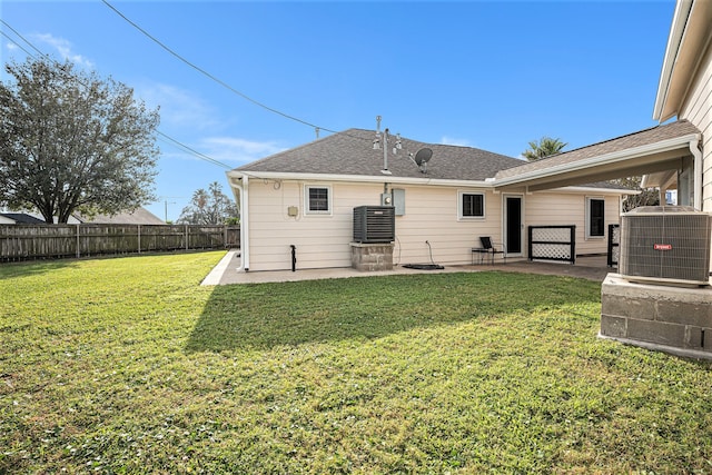 rear view of property with a lawn, a patio, and central AC unit