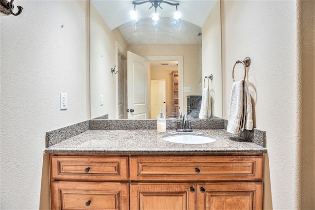 bathroom featuring vanity and lofted ceiling