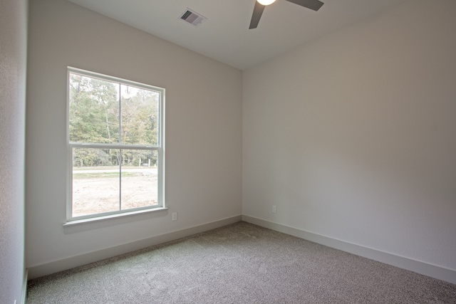 carpeted empty room featuring ceiling fan and a wealth of natural light