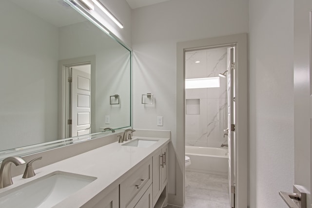 full bathroom featuring tile patterned flooring, vanity, tiled shower / bath combo, and toilet