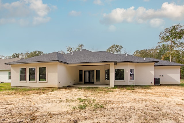 rear view of property with cooling unit and a patio