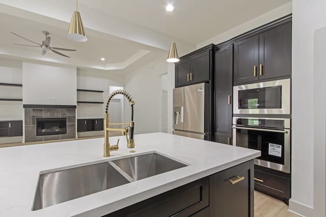 kitchen featuring appliances with stainless steel finishes, ceiling fan, hanging light fixtures, and sink