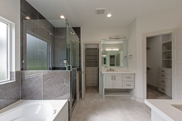 bathroom featuring plus walk in shower, vanity, and tile patterned floors