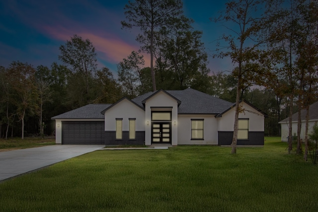 view of front of property with a garage and a yard