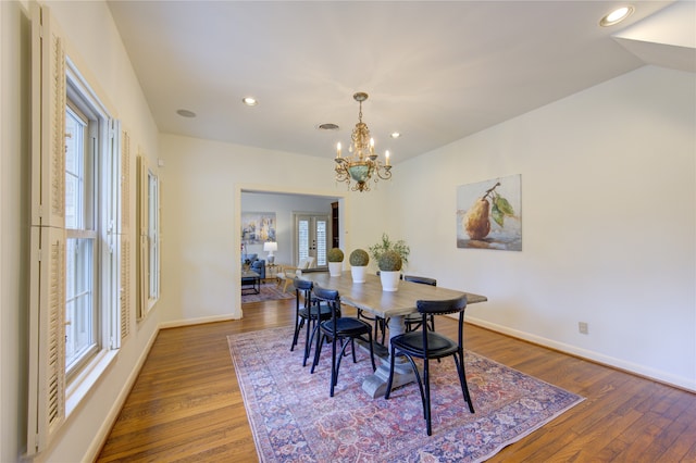 dining area with a chandelier, hardwood / wood-style floors, french doors, and plenty of natural light