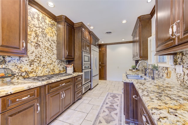 kitchen with built in appliances, tasteful backsplash, crown molding, and sink