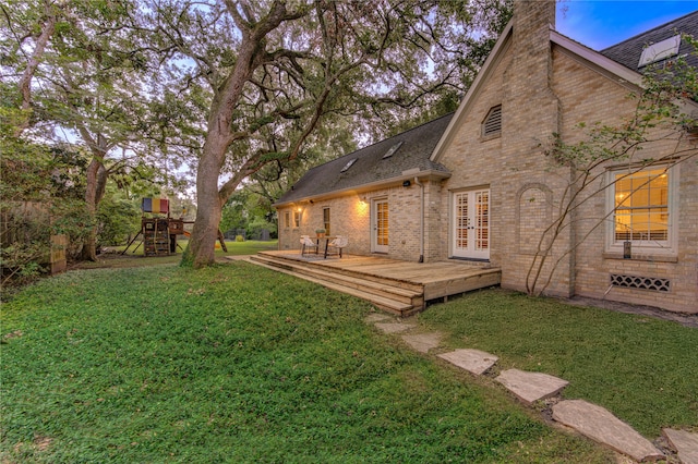 view of yard with french doors, a playground, and a wooden deck