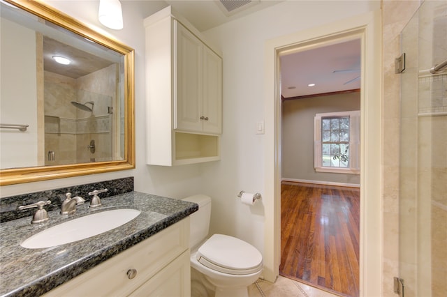 bathroom with hardwood / wood-style floors, toilet, an enclosed shower, and vanity