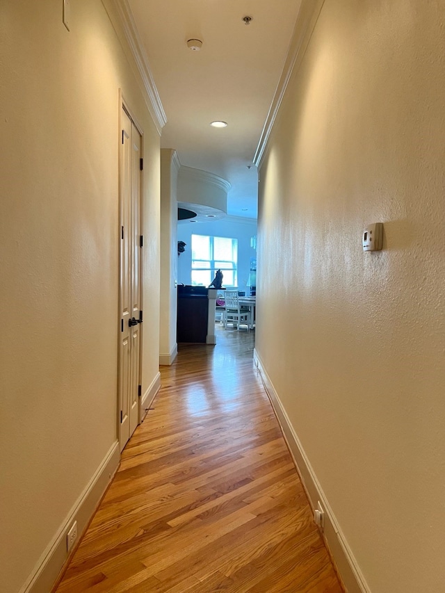 corridor featuring light hardwood / wood-style flooring and ornamental molding