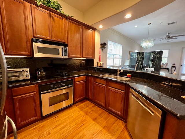 kitchen featuring appliances with stainless steel finishes, backsplash, crown molding, sink, and light hardwood / wood-style flooring