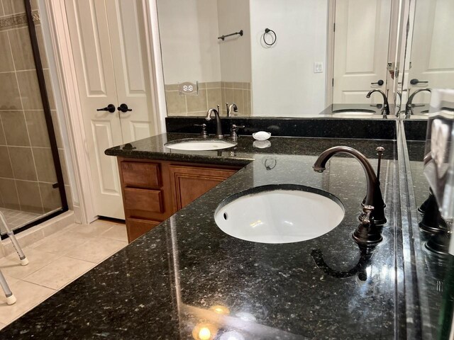 58 Briar Hollow Ln Unit 204, Houston, TX 77027 - bathroom with double vanity, tile patterned flooring, and a stall shower