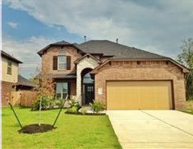 mediterranean / spanish-style home featuring a garage and a front lawn