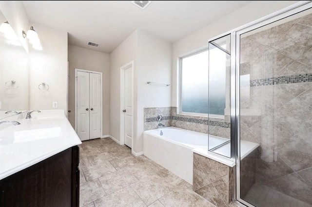 bathroom with vanity and shower with separate bathtub