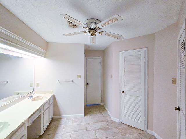 bathroom with a textured ceiling, vanity, tile patterned floors, and ceiling fan