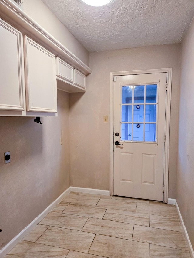 laundry area featuring cabinets, a textured ceiling, and electric dryer hookup