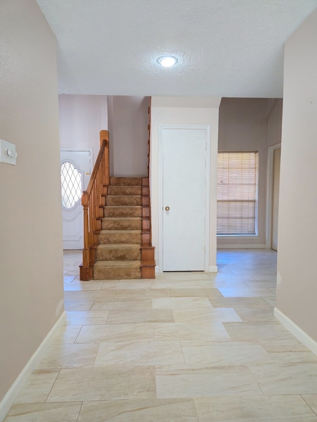 hall with a textured ceiling