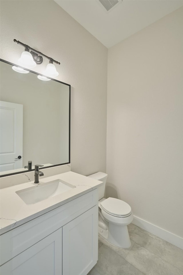 bathroom featuring tile patterned flooring, vanity, and toilet